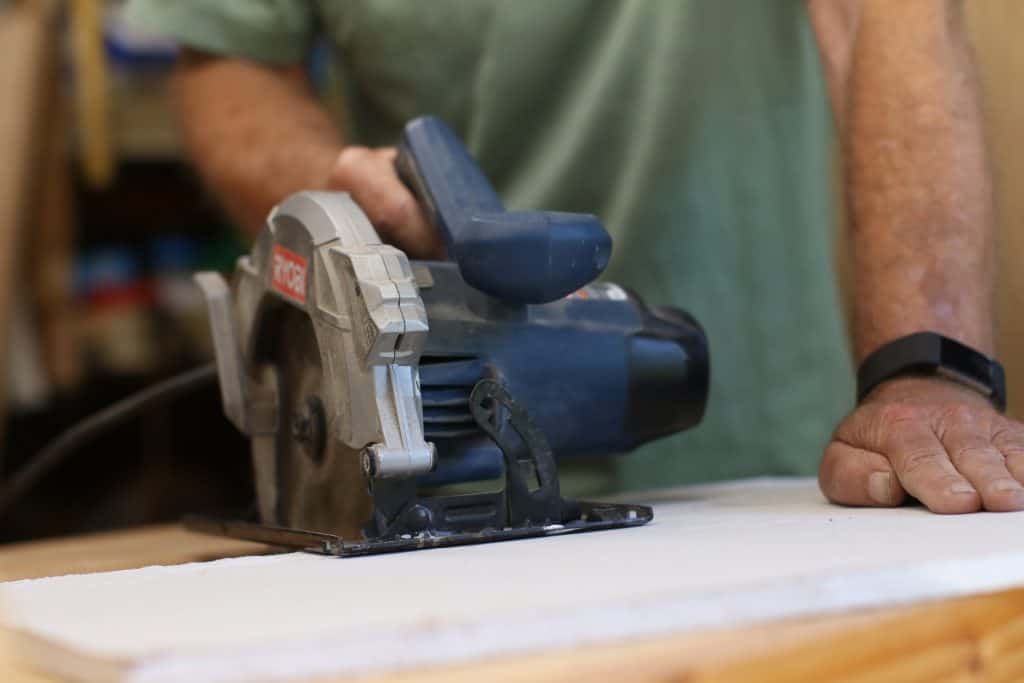 Man uses a circular saw for cutting cement backer