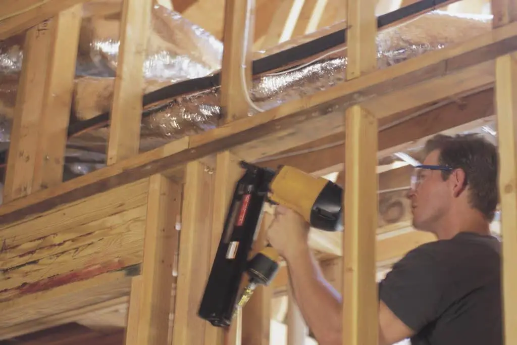 Man using a framing nailer in construction work