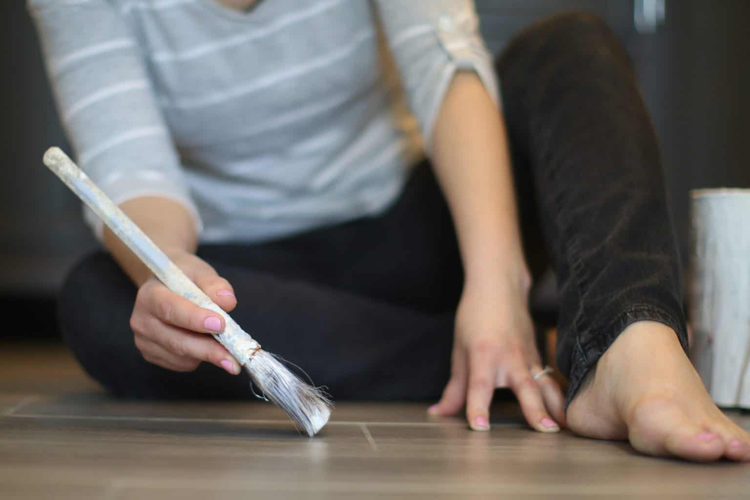Person applying polyurethane on the floor