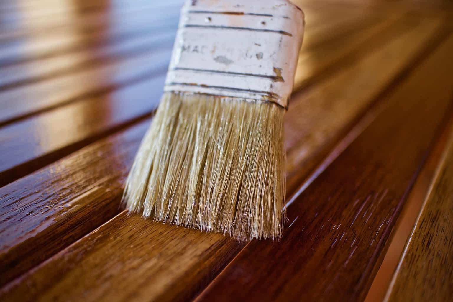 Brush being used to apply wood finish