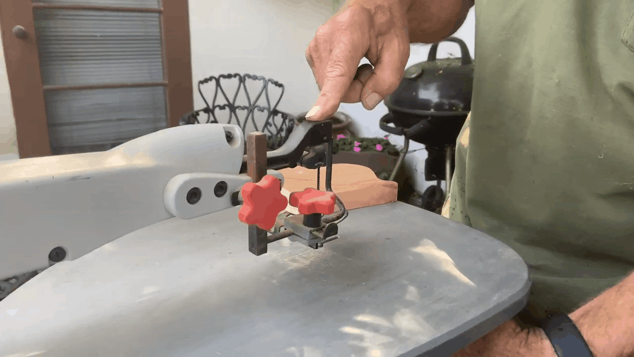 Man pointing at the scroll saw blade