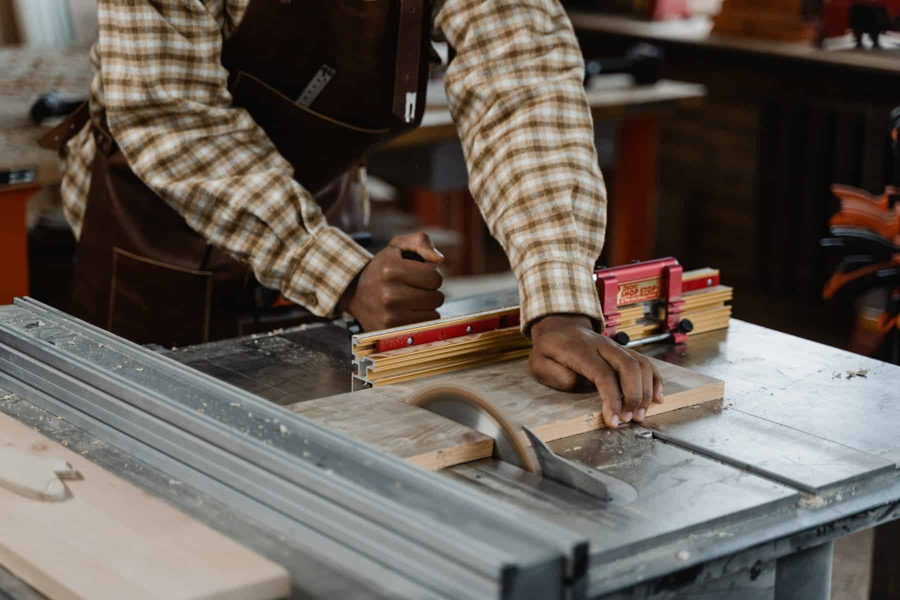A man cutting a wood using a table saw